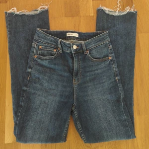 Blå bootcut jeans  - Snygga blå jeans från Perfect Jeans i storlek 34. Modellen har utsvängda ben med croppad längd och hög midja. Fransiga benslut.