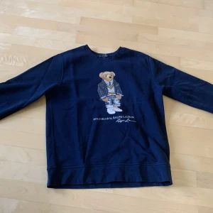 Polo Bear Ralph Lauren sweatshirt  - Säljer en marinblå Ralph Lauren Sweatshirt med den klassiska björnen på framsidan! Tröjan är i storlek XL (18-20) i junior storlek. Tröjan är i mycket fint skick och bara använt ett fåtal gånger! Hör av dig vid frågor!😃