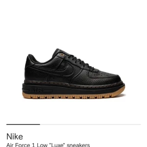 Nike Air Force 1 Luxe svart skinn - Nike Air Force 1 Luxe sneakers i svart skinn med låg silhuett och robust gummisula i brunt. Obetydligt använda, svart krokodil i storlek 42. pris 800kr 
