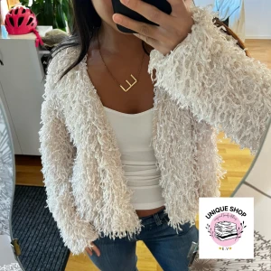 Vit fluffig teddyjacka - Säljer en supermysig vit teddyjacka med långärmad design och loose passform. Jackan har en fluffig, lurvig yta som ger en cool och trendig look. Perfekt för dig som vill sticka ut och hålla dig varm. Passar till jeans och sneakers för en chill vibe.