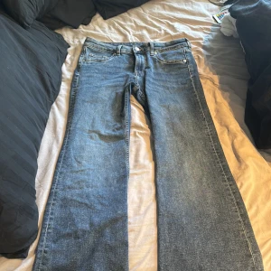 Blåa bootcut jeans low waist  - Säljer mina blå gråa jeans från h&m då dem blivit förstora, är super sköna och fina har använt dem ett fåtal gånger då jag köpt dem innan sommaren, dem är även low waist.