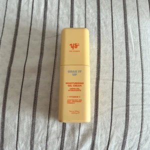 Yes Studio Soak It Up gel cream - Fräsch ansiktskräm i en ljusgul, fyrkantig plastflaska från Yes Studio. Innehåller vitamin C och har en lätt gel-formula som återfuktar huden. Cruelty free och vegansk produkt med smart pumpfunktion. Perfekt att ha med i väskan för en snabb boost.
