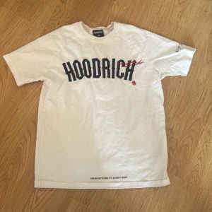 Vit t-shirt från Hoodrich - Säljer en vit t-shirt från Hoodrich med tryck både fram och bak. T-shirten har korta ärmar och texten 'From Nothing To Something' tryckt på baksidan. Perfekt för en avslappnad stil.