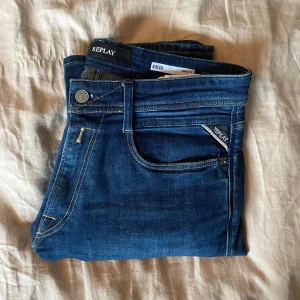 Blå jeans från Replay - Snygga blå jeans från Replay, modell Rocco med komfortpassform. Klassisk femficksdesign med dragkedja och knapp. Perfekta för en avslappnad stil.