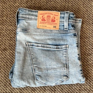 Ljusblå jeans från Pearson, modell 308 - Säljer ett par ljusblå jeans från Pearson, modell 308. Jeansen har klassisk femficksdesign, regular fit och är tillverkade i stretchig denim med 99% bomull och 1% lycra. Perfekta för en avslappnad stil.