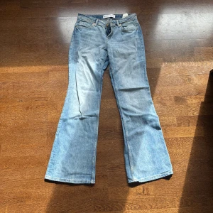 Ljusblå bootcut jeans från Bershka - Säljer ett par ljusblå bootcut jeans från Bershka. Jeansen har klassisk femficksdesign, dragkedja och knapp framtill samt utsvängda ben. Perfekta för dig som gillar en retroinspirerad look. Använda ca 2 gånger så extremt bra skick!