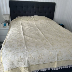 Överkast  - Oanvänd helt ny bredd 185cm- lång 233 cm kuddar 42*42 cm guld och beige färgar