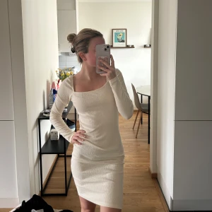Ljusbeige ribbad klänning med lång ärm - Säljer en ljusbeige ribbad klänning med lång ärm och fyrkantig ringning. Klänningen är tight och har en kort längd, perfekt för dig som gillar en enkel men stilren look. Superfin att styla med sneakers eller boots!