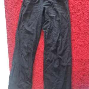 Svarta linnebyxor - Svarta linnebyxor med rak passform och normal midja. Perfekta för varmare dagar tack vare det lätta materialet. Klassisk och enkel design utan synliga detaljer. Storlek 158/164cm