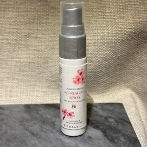 Ny! Rituals The Ritual of Sakura Refreshing Spray - Helt ny! Fräsch doftspray från Rituals, The Ritual of Sakura, med noter av rismjölk och körsbärsblom. Perfekt för att ge kläder och textilier en uppfriskande doft. Kompakt flaska med vacker design och blommotiv.