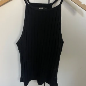 Svart ribbad linnetopp från BikBok - Snygg svart ribbad linnetopp från BikBok i storlek XS. Perfekt för en stilren look med smala axelband och en enkel design. Passar utmärkt till både jeans och kjol.