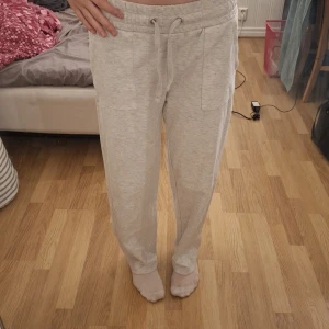 Grå mjukisbyxor med snörning - Säljer ett par bekväma grå mjukisbyxor med snörning i midjan. Byxorna har en loose passform och är perfekta för en avslappnad stil. De har praktiska fickor framtill och en elastisk midja för extra komfort.