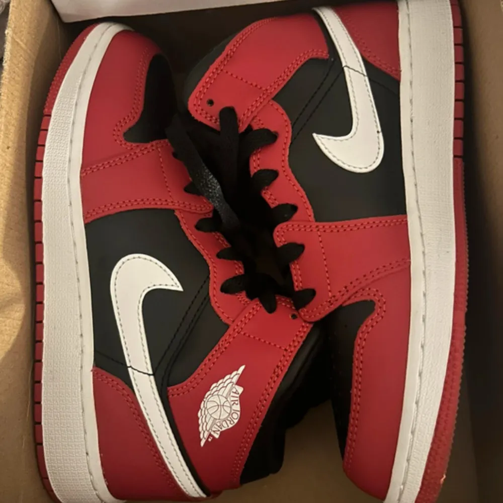 Säljer ett par klassiska Nike Air Jordans med svart bas, röda paneler och vita detaljer. Skorna har vit swoosh, svart snörning och röd Air Jordan-logga. Perfekta för dig som gillar streetstyle och sneakers med ikonisk design.. Kengät.