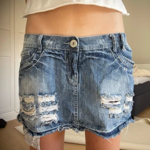 Jeanskjol med slitningar - Galet snygg jeanskjol med coola slitningar. Midjemåttet tvärs över ca 42cm men passar mig som har höftomkrets ca 85-86cm❤️