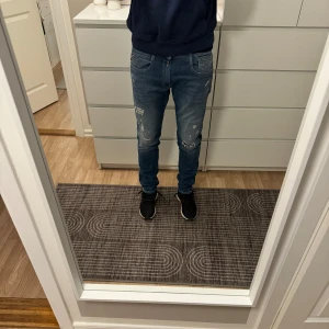 Blå slitna replay jeans med slim fit - Säljer ett par blå replay jeans med slim passform och slitna detaljer på benen. Storlek 30x32
