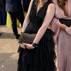 Svart långklänning med volanger - Svart volang maxiklänning även min gamla balklänning. Jag klippte av nedersta volangen men underklänningen är uppvikt med säkerhetsnålar så den inte syns under. Den gick till min ankel när jag på 160 hade klackar på 3 cm. Dragkedjan var trasig när jag fick den så den går bara till dit bilden visar och har även sytt på en hake. Eftersom jag gjort så mkt med klänningen är priset såpass bra när den kosta över 1000 ny.