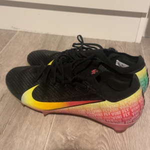 Nike Mercurial fotbollsskor svart/gul - Nike mercurial fotbollsskor. Vinicius signaturskor nästan helt nya endast tränat med dessa 50min. Säljer dom då de är för små. Nypris 3499kr säljer för 2799kr. Påse och allt följer med. Kom med bud. Är även öppen för byte mot ett par nya Nike phantom 