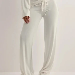 Vita mjukisbyxor med snörning - Supermjuka och sköna vita mjukisbyxor med breda ben och dragsko i midjan. Byxorna har loose fit och är perfekta för en chill look. Tillverkade i ett stretchigt och mjukt material som känns riktigt bekvämt. Skulle inte säga att de är genomskinliga💕 Säljer då de var förstora