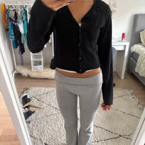 Svart kofta  från H&M - Svart croppad cardigan jacka från H&M med långa ärmar och knappar framtill. Enkel och stilren design som passar till många outfits. Mjuk och skön känsla, perfekt för lager-på-lager. Snygg att bära både öppen och stängd.