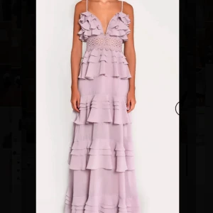 Ljuslila långklänning med volanger - Superfin långklänning i ljuslila med flera lager volanger och spets upptill. Perfekt till olika tillfällen. Klänningen är endast använd 1 gång och är som ny. Köpt på true decadence hemsida för 2350kr. Kom privat för fler frågor (pris går att diskutera vid snabb affär)