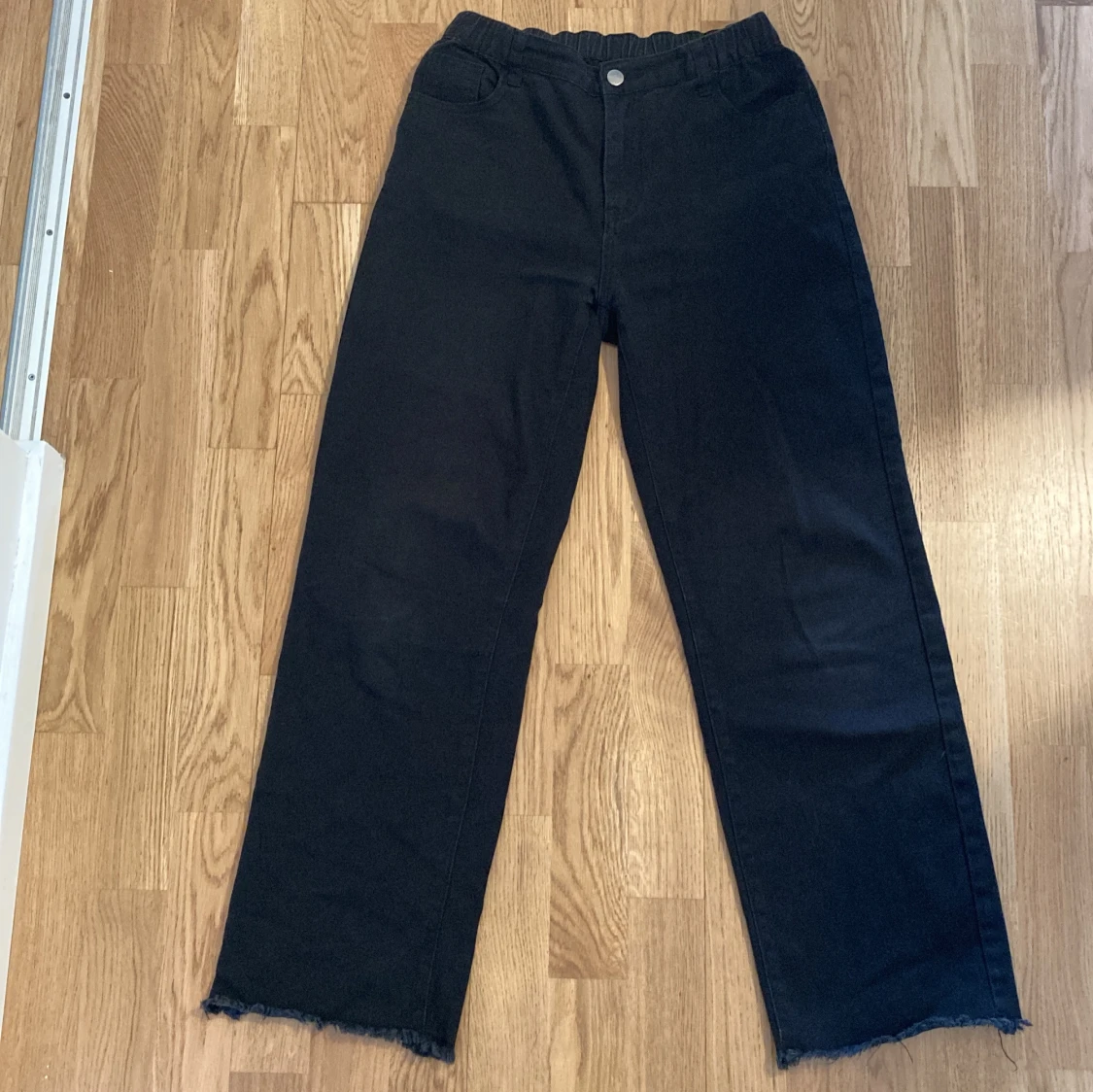 Svarta raka jeans med råa kanter