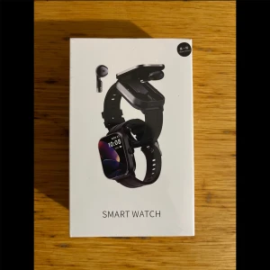 Svart smartklocka med hörlurar - Säljer smartklockor med tillhörande earbuds. Jag har flera exemplar, och alla är nya och finns i obrutna förpackningar.  Några Funktioner: – Ringa & svara på samtal – Stegräknare, kalorimätare & aktivitetsmätning – Sömnkontroll – Musik via earbuds – Få notiser från mobilen – Alarmfunktion – Egen app för att styra och anpassa klockan - & Mycket mer  Ett exemplar = 499 kr Pris går att diskutera, skriv vid intresse!