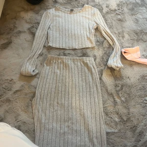 Grå ribbad långkjol från SHEIN - Säljer en grå långkjol från SHEIN i storlek XS. Kjolen är ribbad med vertikala ränder och har en mjuk, stretchig känsla. Perfekt för dig som gillar en enkel men snygg look. Passar till både sneakers och boots.