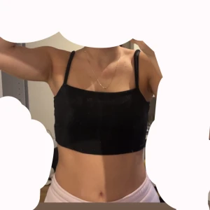 Svart ribbad croppad linnetopp - Svart croppad linnetopp från H&M med smala axelband och ribbad struktur. Enkel och stilren modell som passar perfekt till jeans eller kjol. Mjuk och stretchig för en bekväm känsla. Säljes i storlek S. Passar XS och M oxå. Använd några gånger.