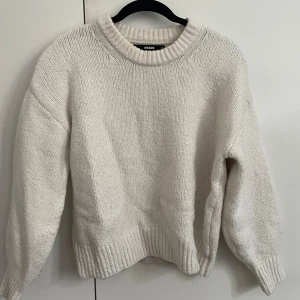 Vit stickad tröja från Bik Bok - Mysig vit stickad tröja från Bik Bok med rund halsringning och ribbade muddar vid ärmslut och nederkant. Perfekt för lager-på-lager och chill dagar. Oversized fit för en avslappnad vibe.