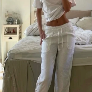 Linnebyxor - Säljer ett par fräscha vita linnebyxor med raka ben och dragsko i midjan, använda 2 gånger. Byxorna har  fickor framtill och är perfekta för varma dagar. Lätta och luftiga med avslappnad passform, perfekta linnebyxor enligt mig💕🥰 original pris 900kr