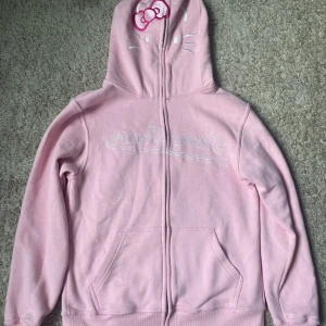 Limited edition StarrySonder Hello kitty hoodie - Säljer en rosa hello kitty hoodie från StarrySonder💕 Säljer den då den aldrig kom till använding och är för stor för mig. Nyskick💕 Nypris ca 1000kr💕 Passar folk med storlek M och säkert L då den är väldigt oversized och lång💕Pris går att diskutera!!🩷