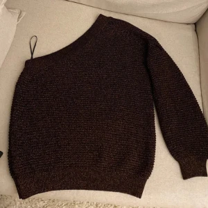 Off-shoulder tröja från Mango! Ny!  - Säljer en snygg brun glittrig tröja från Mango med en trendig offshoulder-design. Perfekt för att sticka ut med stil. Tröjan har en bekväm passform och är tillverkad i ett glittrande material som ger en extra touch av glamour.Jättefint skick! Den är reäl i tyget och glittrar jättemycket! Dock svårt att fånga på bild! Men kika på bilderna 3-5 så syns det lite bättre iaf! 🌸