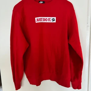 Röd Nike sweatshirt Just Do It S - Röd sweatshirt från Nike med klassiskt 'Just Do It.' tryck på bröstet. Tröjan har rund hals, långa ärmar och är gjord i mjuk bomullsmix. Perfekt för dig som gillar sportig och clean stil. Köptes på Stadium för 700kr