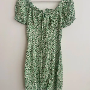 Grön blommig klänning - Super söt grön klänning med blommigt mönster och korta ärmar. Perfekt för en somrig look!❤️