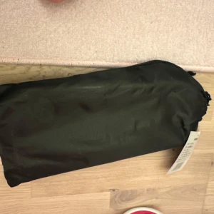 Svart hopfällbar stol - Praktisk och kompakt svart hopfällbar stol med metallram. Perfekt för camping eller utflykter. Lätt att bära med sig tack vare den medföljande väskan.