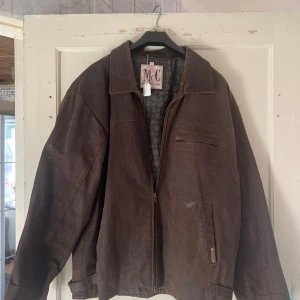 Brun jacka från McC Collection - Säljer en brun jacka från McC Collection. Jackan har en klassisk design med dragkedja och en innerfoder med mönster. Perfekt för höst och vår. Den har långa ärmar och en bekväm passform.