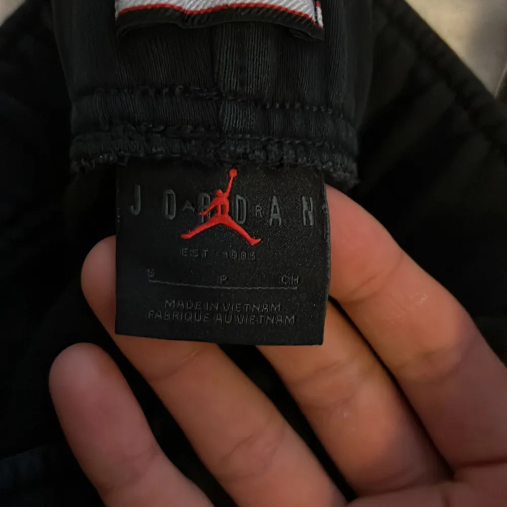 Säljer ett par svarta mjukisbyxor från Jordan med elastisk midja och snörning. Byxorna har en liten logga på framsidan och en bakficka. Perfekta för en avslappnad stil.. Farkut & Housut.