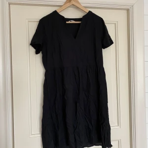 Svart klänning med v-ringning - Snygg svart klänning med v-ringad hals och korta ärmar. Använd ett fåtal gånger!