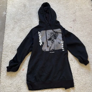 Svart hoodie med tryck - Säljer en svart hoodie med tryck på framsidan. 