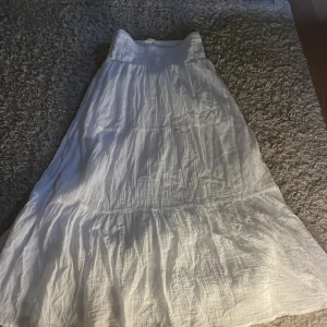 Vit långkjol från Gina Tricot - Säljer en vit långkjol från Gina Tricot. Kjolen har en luftig och bekväm passform med flera lager som ger en fin volym. Perfekt för varma dagar och kan enkelt matchas med olika toppar. 🌼