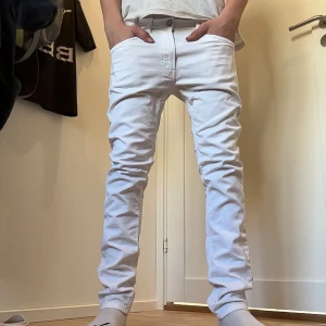 Vita jeans från Diesel - Snygga vita jeans från Diesel med en tight passform. Byxorna har en klassisk design med fem fickor och en knappgylf. Perfekta för en stilren look. Passar 158/164.Passform slim/skinny