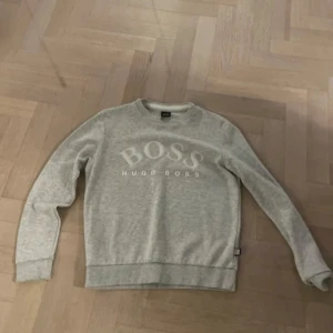 Grå sweatshirt från Hugo Boss - Säljer en grå sweatshirt från Hugo Boss med deras logga tryckt på framsidan. 9/10 skick. Hör av er 🙌🏼