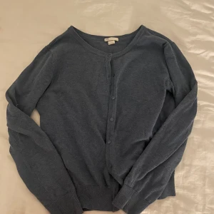 Blå kofta från H&M - Säljer en klassisk blå kofta från H&M. Den har långa ärmar och knappar framtill. Perfekt för lager-på-lager under kyligare dagar. 🧥