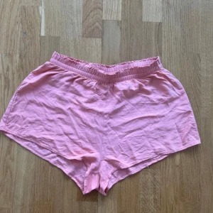 Aprikosfärgade shorts från H&M Divided stl 38 - Säljer ett par mjuka och bekväma rosa shorts från H&M Divided. Perfekta för varma sommardagar med en elastisk midja för extra komfort. Passar utmärkt för en avslappnad stil.