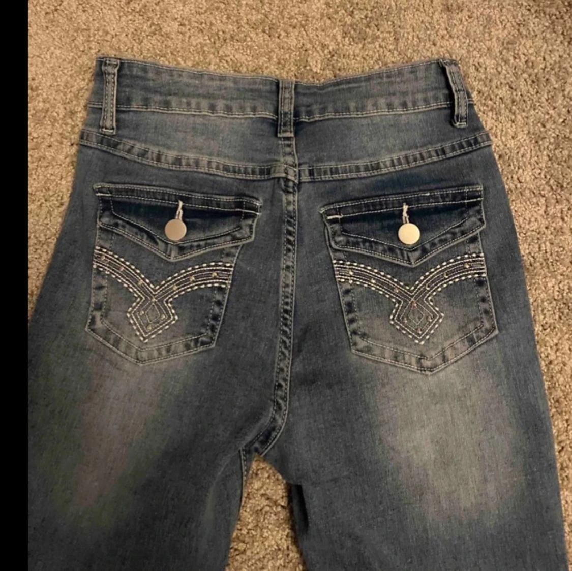 Blå jeans med broderade bakfickor