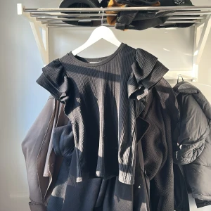 Svart ribbad topp från Zara - Säljer nu denna topp som inte kommit till användning eftersom jag har många andra, jättesöt med volanger och sitter väldigt fint på🥰