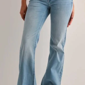 Ljusblå bootcut jeans - Snygga ljusblå bootcut jeans med rosa detaljer, ifrån Nelly. Knappt använda då jag valde fel storlek, dom är max använda 8 gånger och är som nya  (det ända som jag har märkt är att dom har blivit lite slitna längst ner)💕💕