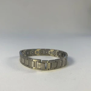 Lacoste silverfärgat armband - Stilrent armband från Lacoste i silverfärgad metall med rektangulära länkar och diskret mönster på varje länk. Helt ny kommer som på bild.