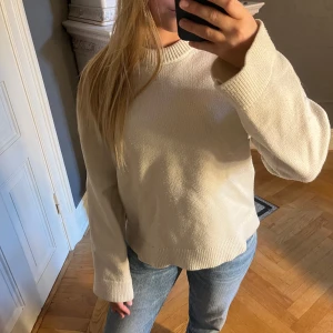Beige stickad tröja Gina Tricot - Säljer en beige stickad tröja från Gina Tricot i storlek XS. Tröjan har en rundad, ribbad halsringning och långa ärmar med avslappnad passform. Tjocktröjan har en liten grå fläck under halsen därav priset annars helt ny 😊