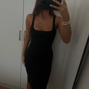 Svart tight midiklänning - Svart midiklänning med smala axelband och fyrkantig urringning. Klänningen är figurnära och perfekt för dig som gillar en enkel men snygg stil. Storleken är S men sitter även som en XS 🌺